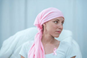 cancers féminins, boiron, homéopathie, femme atteinte d'un cancer qui porte un foulard rose sur la tête