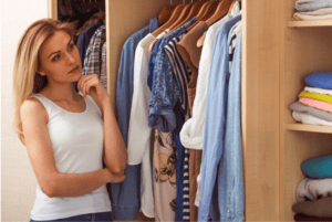 vêtements je garde ou pas ?, femme en traine réfléchir devant son dressing