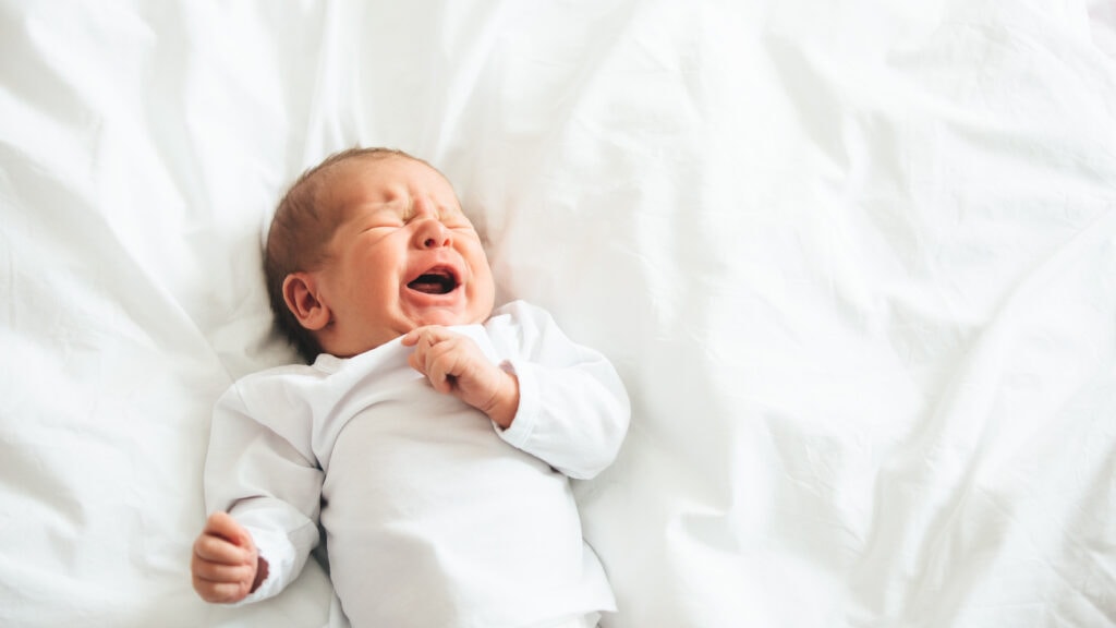 décoder les pleurs de bébé, bébé sur un lit qui pleure